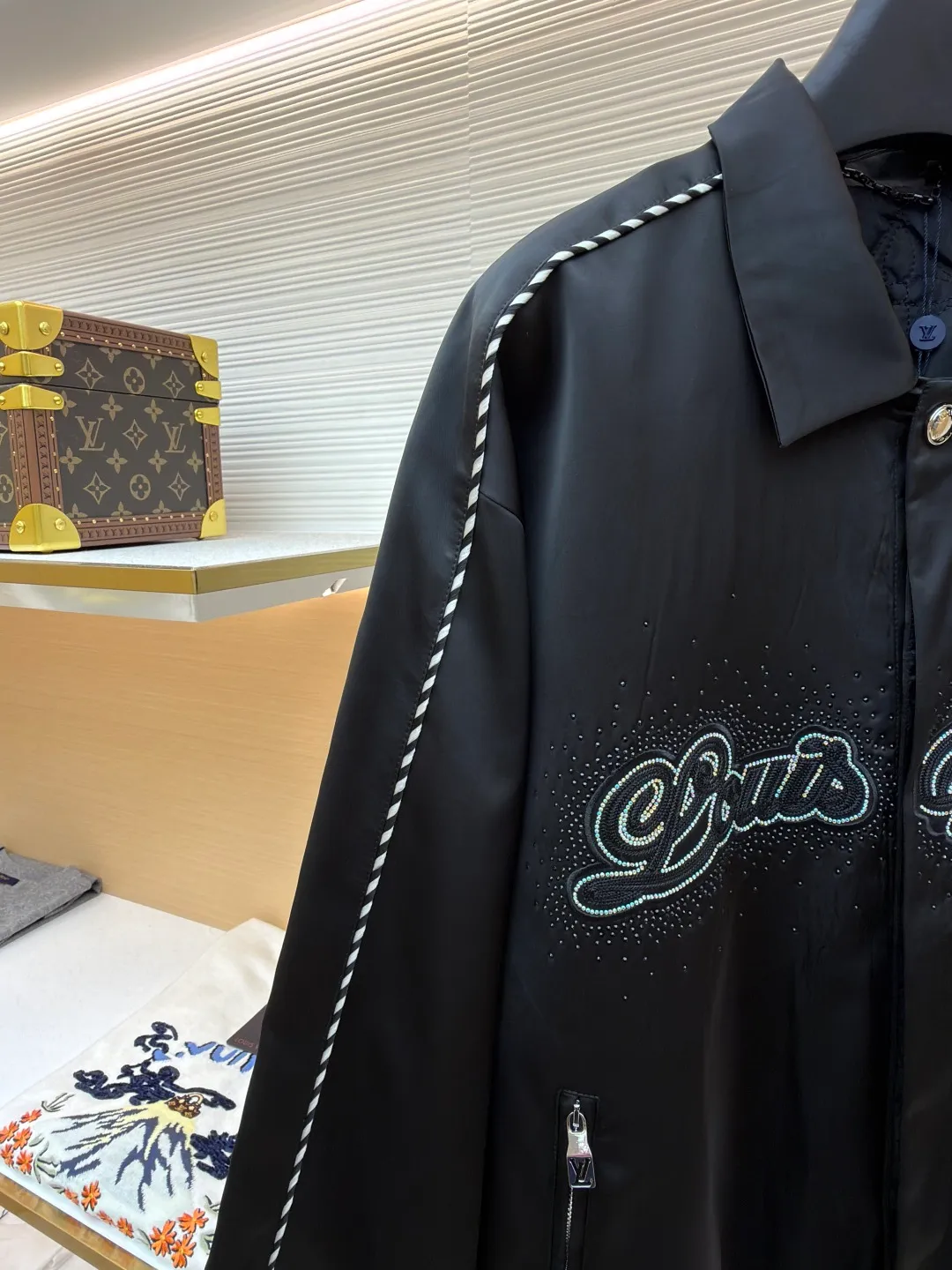 LOUIS VUITTON chest embroidered rhinestone jacket ●Original version: Purchased and developed at 22889 ●Item number: 1681600-B70 ●Material: 100% cotton ●Technology: rhinestone production ●Color: black ●Version: Fitted version ●Weight: about 740 grams ●Size: 46-48-50-52 ●Description: This Louis Vuitton jacket is made of high-quality black satin material, with a delicate texture and rich luster. The craftsmanship incorporates a variety of advanced production technologies: the eye-catching brand logo on the chest is combined with three-dimensional embroidery and hot-drilling technology. The stitching is precise and layered, highlighting the brand's unique recognition; the black and white braided belt decoration on the shoulders and sides not only increases the visual hierarchy, but also enhances the overall sense of fashion and sophistication. The neckline and cuffs are neatly cut and have smooth lines, showing a simple yet high-end style. The zipper and metal buckle have exquisite details and outstanding texture. Manual tile measurement, the error of 1-3CM is within the normal range, which is also the uniqueness of manual craftsmanship. Whether it is worn for daily wear or paired with a jacket, it can easily show fashionable taste and luxurious temperament. The overall wiring is straight and delicate, the fabric is comfortable and soft, and the color is consistent without color difference. It can be matched with the same style to create a fashionable look and control various occasions. Customized accessories, complete with three standards, same style for men and women!